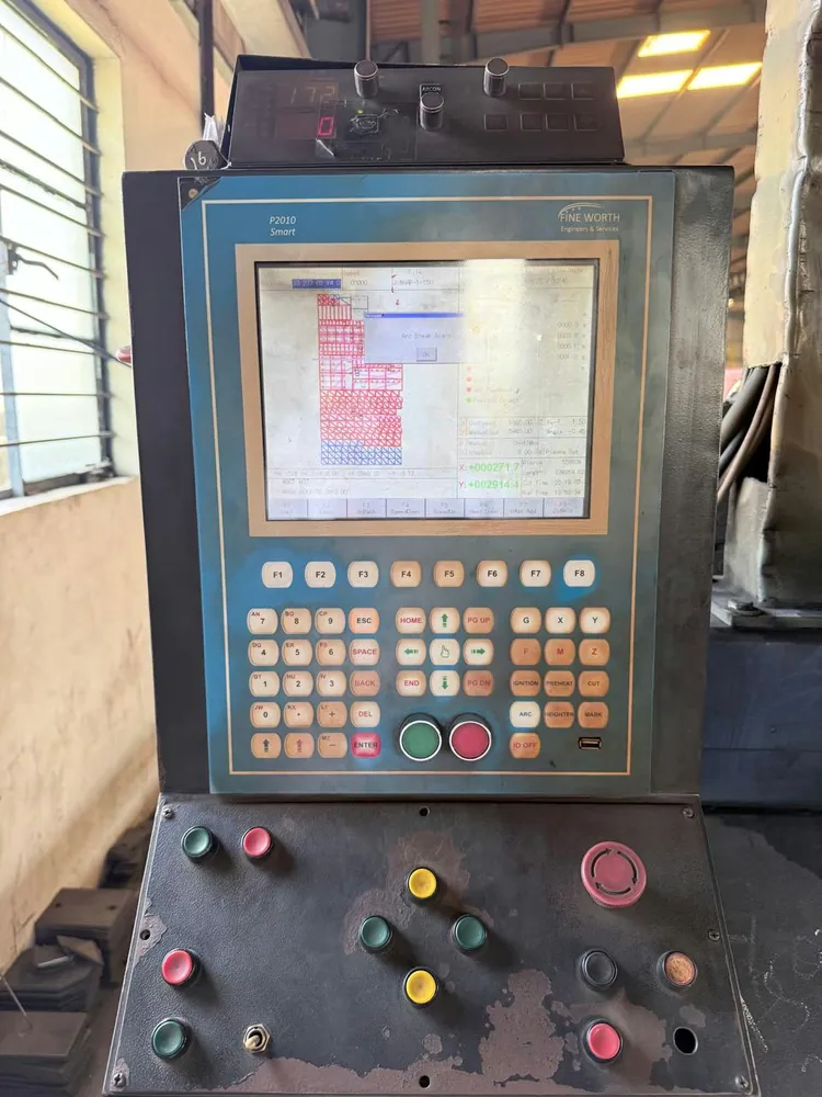 Worn plate-cutting CNC controller showing an arc-break alarm